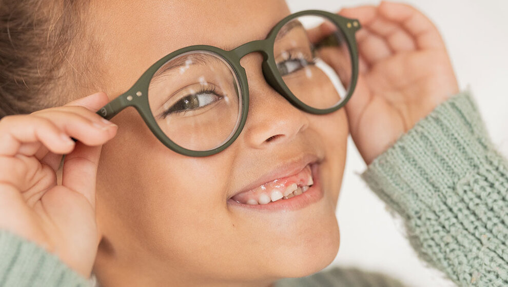 Das Bild zeigt ein lachendes Kind mit einer neuen Brille - Augenlasern Wien, Dr. Atamniy