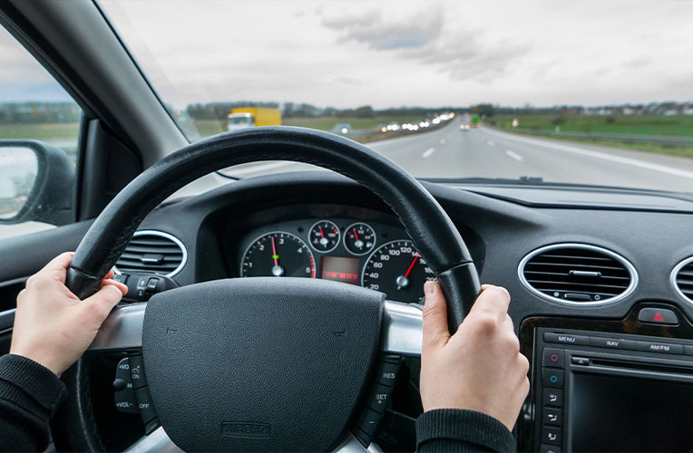 Sicht aus einem Auto hinter dem Lenkrad. Symbolisiert Probleme mit Brillen oder Kontaktlinsen beim Autofahren vor einer Behandlung im Augenlaserzentrum Wien