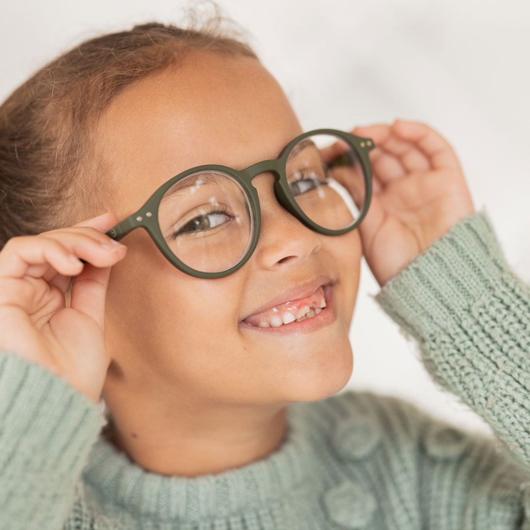 Grinsendes Kind mit Brille beim Augenarzt in Wien