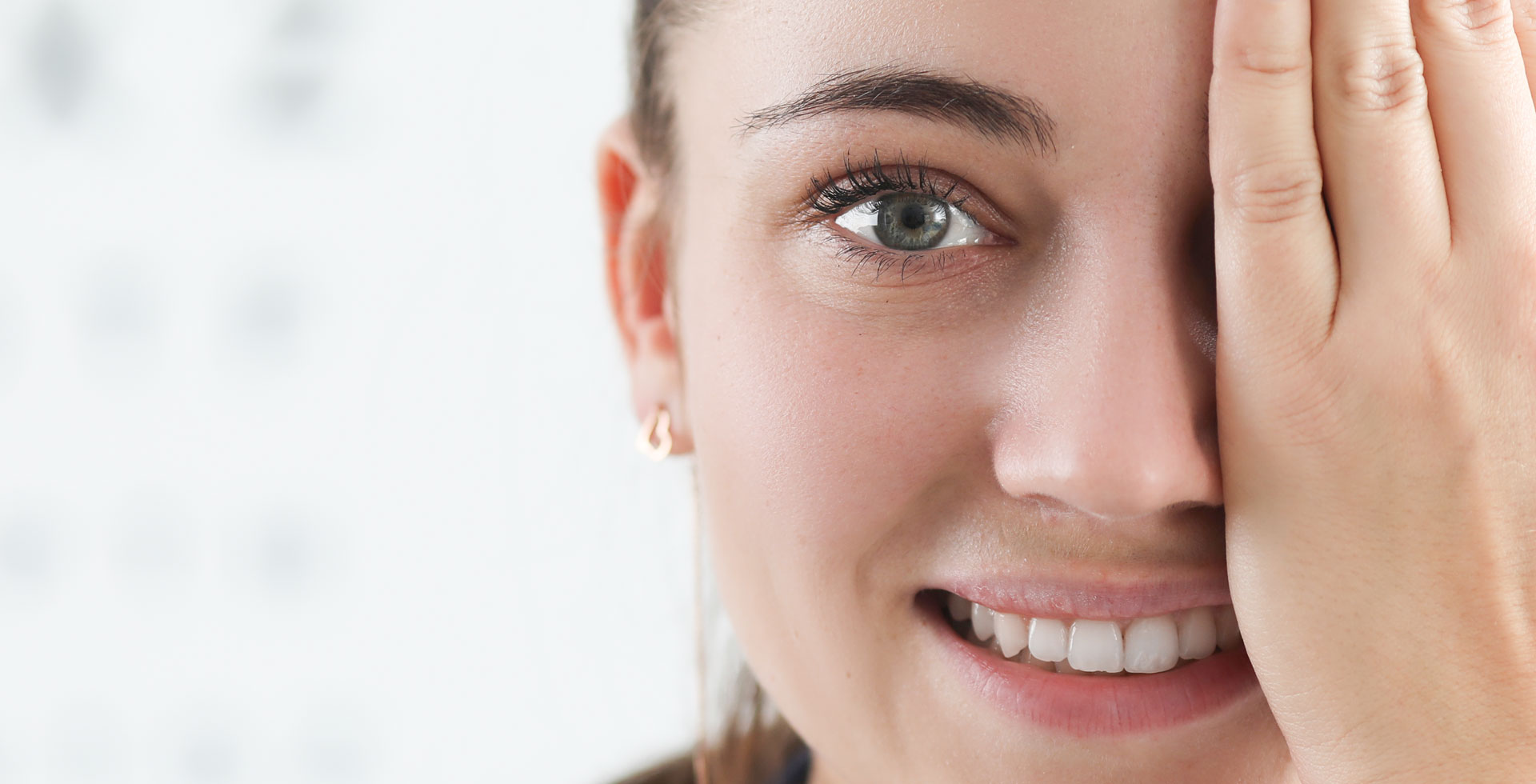 Frau hält sich ein Auge zu. Veranschaulichung einer Fehlsichtigkeit - Augenlasern Wien, Dr. Atamniy