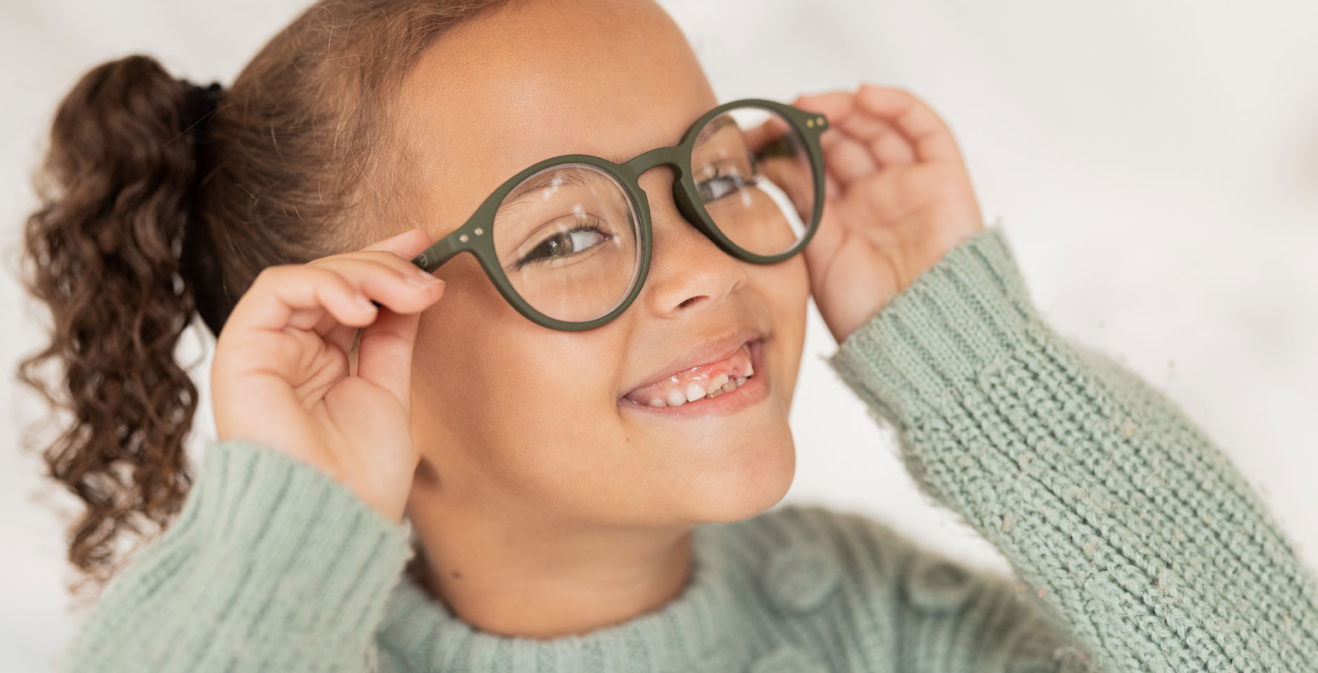 Das Bild zeigt ein lachendes Kind mit einer neuen Brille - Augenlasern Wien, Dr. Atamniy