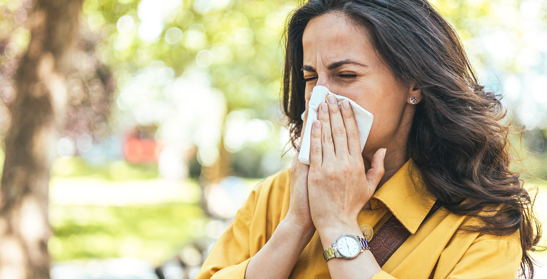 Das Bild zeigt eine Frau, die sich die Nase putzt. Eine Veranschaulichung für die Pollenallergie - Das Bild zeigt ein lachendes Kind mit einer neuen Brille - Augenlasern Wien, Dr. Atamniy